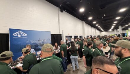 A room with people looking at alaska seafood marketing booth.