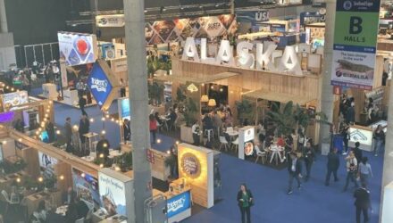 A busy conference hall with ALASKA displayed.
