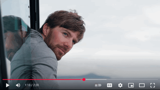 Scruffy white male fisherman leans out of window on board fishing boat