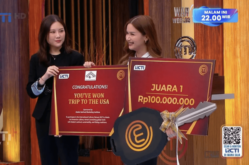 The winner of MasterChef Indonesia smiles as she accepts an award check for her trip to Alaska.