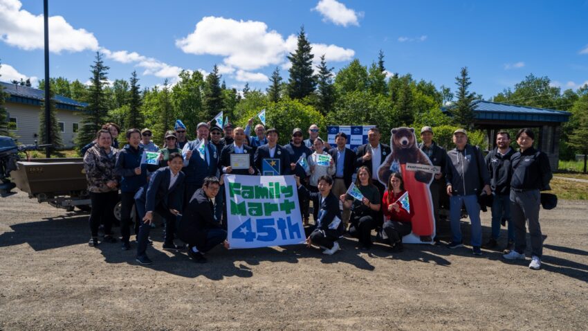 a group people stand with a poster that says 