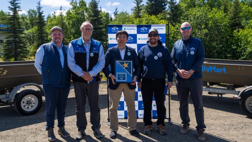 A group of people hold a commemorative plaque. 