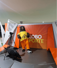 brown bear wearing a yellow shirt in front of an orange background.