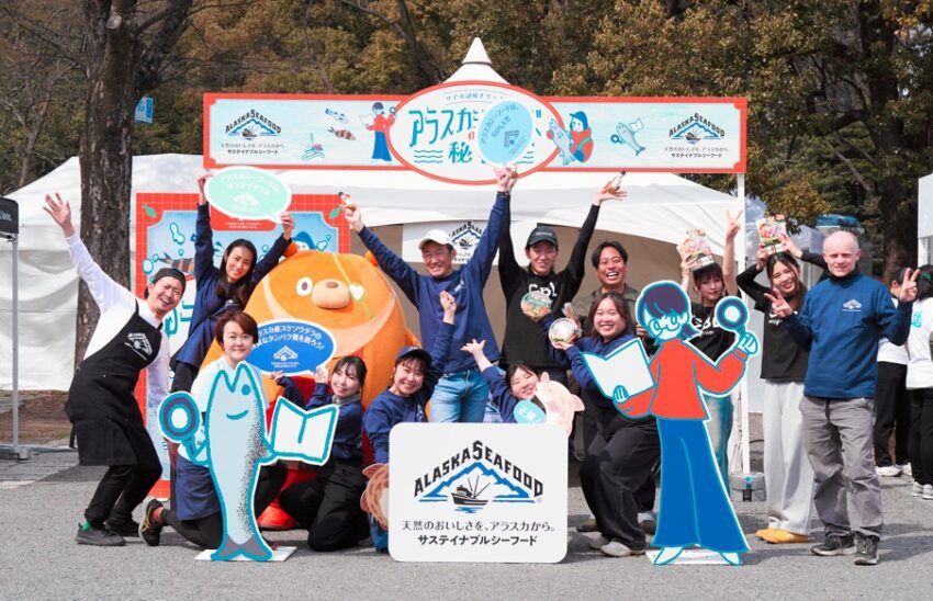 A group of people stand in front of the alaska seafood booth.
