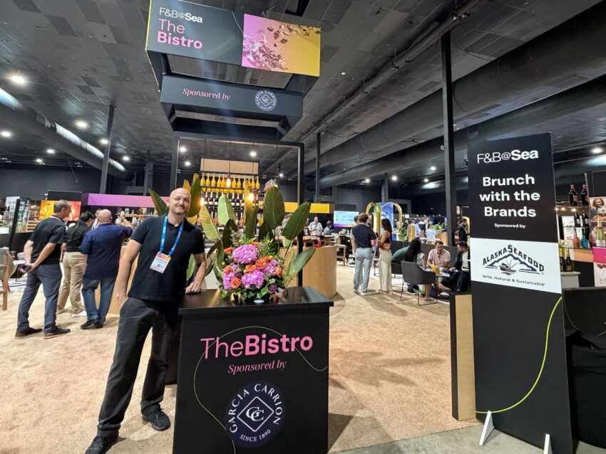 A man stands next to a display table that says The Bistro. 